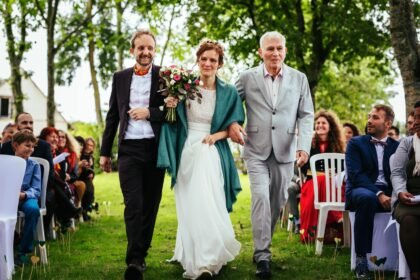 Photo de mariage avec mariée accompagnée de ses papas pour son arrivée à son mariage