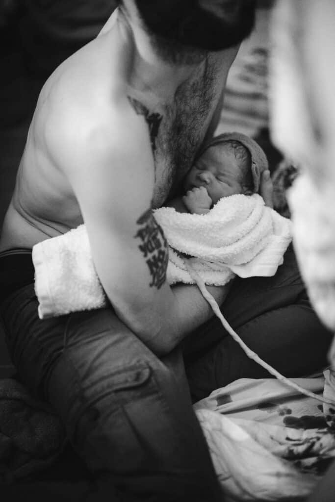 Photographie du cordon ombilical reliant bébé à sa maman alors qu'il est dans les bras de son papa
